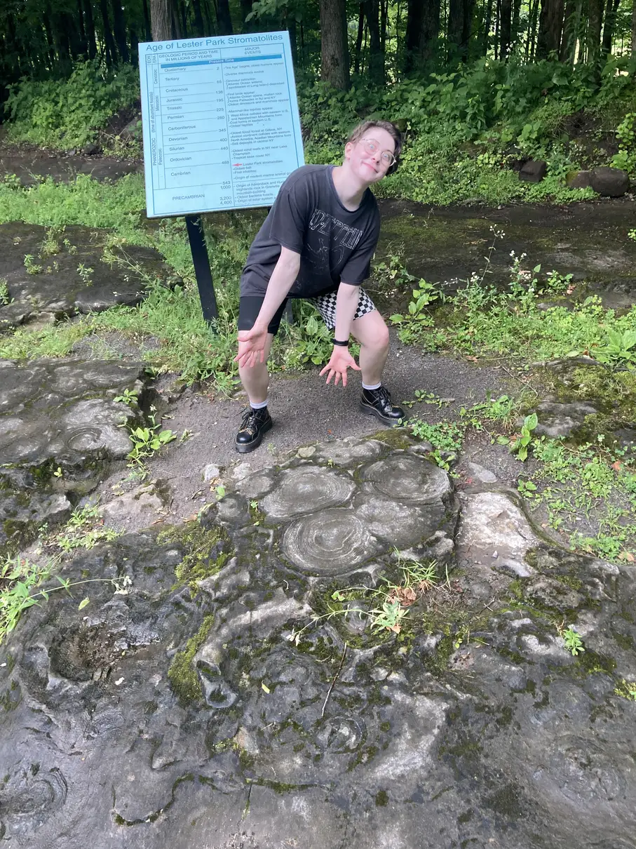 My partner gesturing down at some stromatolite fossils and looking very excited.